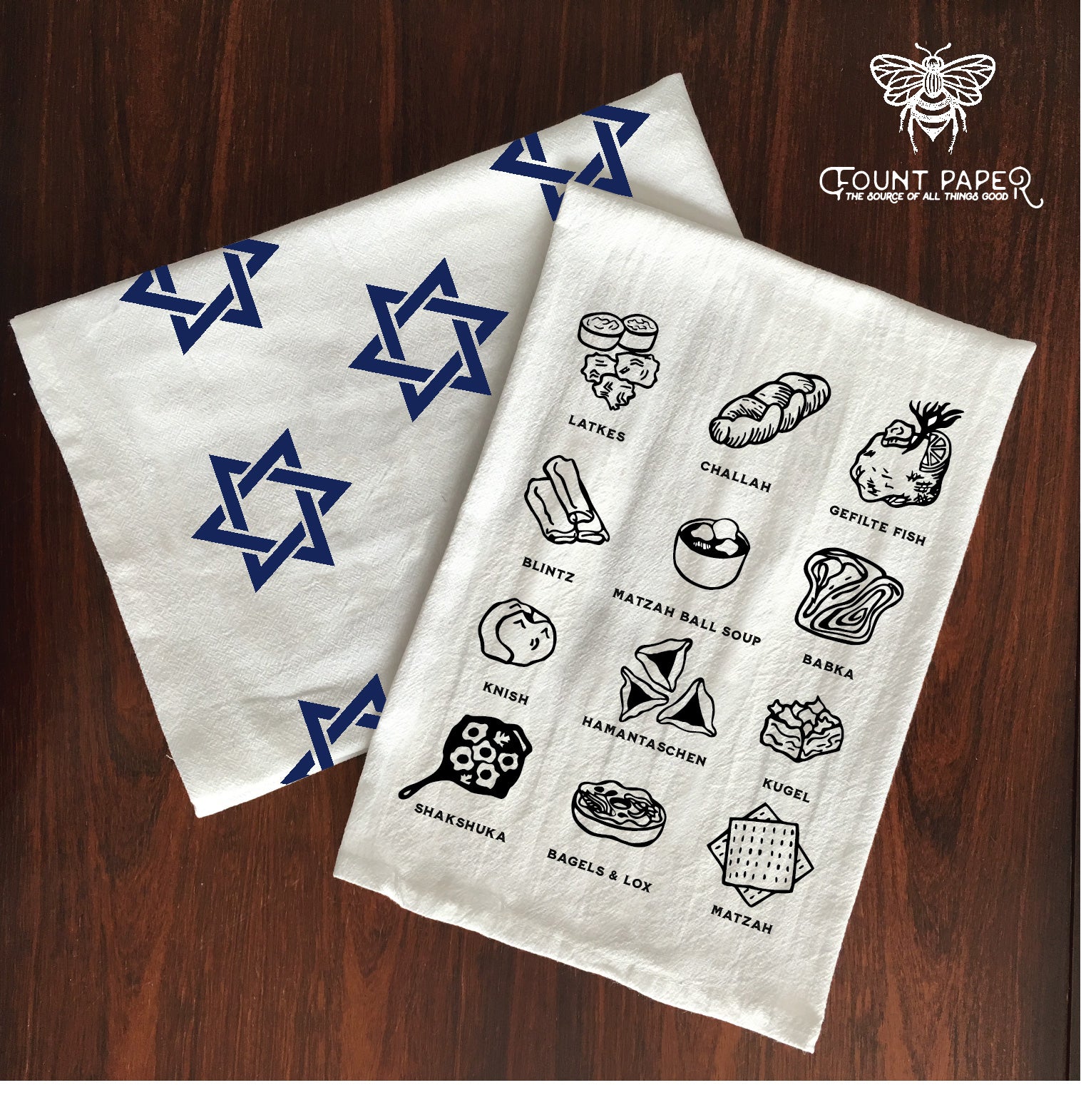 Jewish foods tea towel printed with latkes, challah bread, gefilte fish, blintz, matzah ball soup, babka, knish, hamantaschen, kugel, shakshuka, bagels and lox, and matzah and a Star of David tea towel