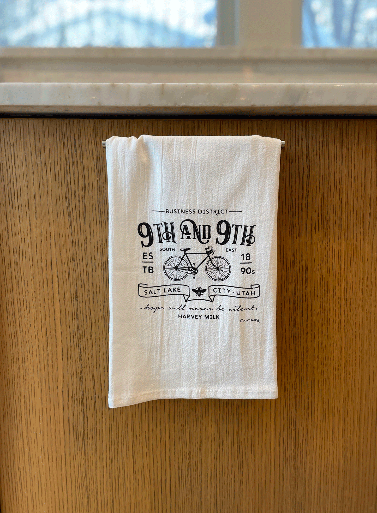White cotton 9th and 9th Salt Lake City Utah tea towel hanging in kitchen